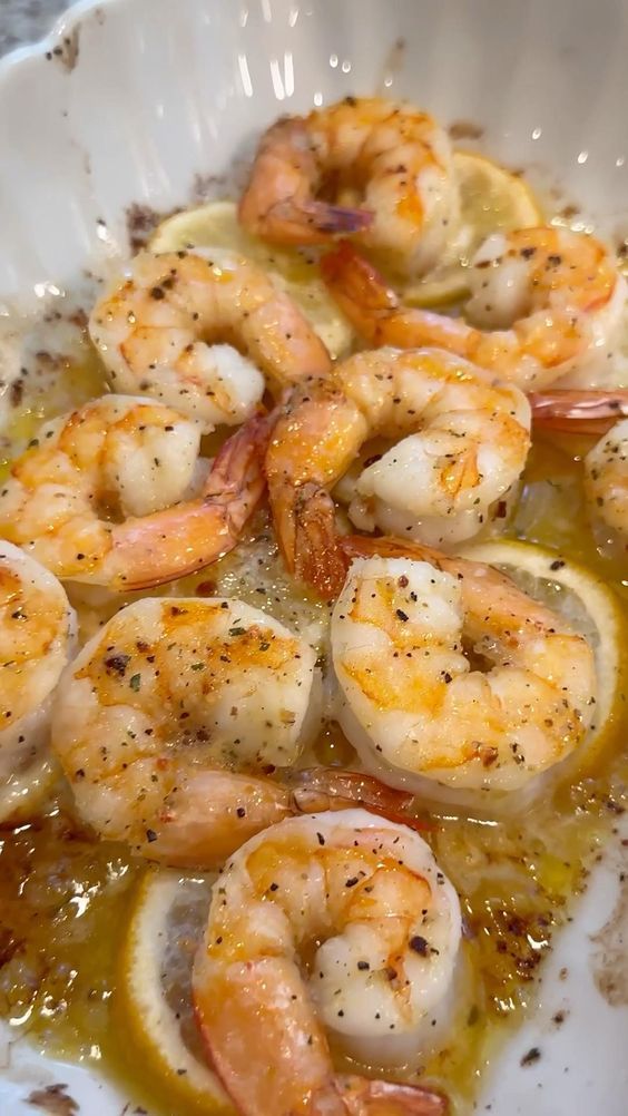 a white bowl filled with shrimp and sauce