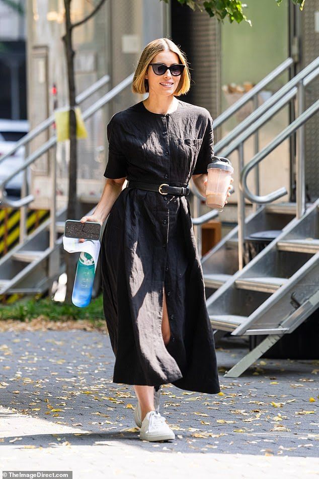 a woman in black dress walking down the street