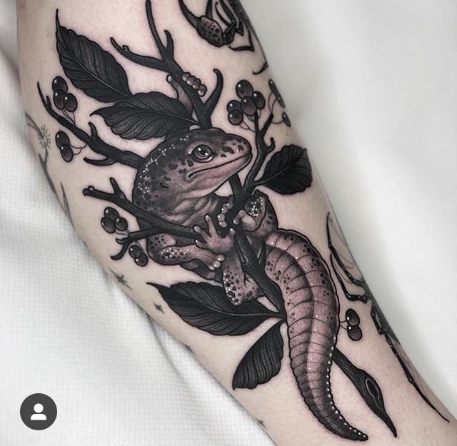 an arm with a lizard and flowers on it