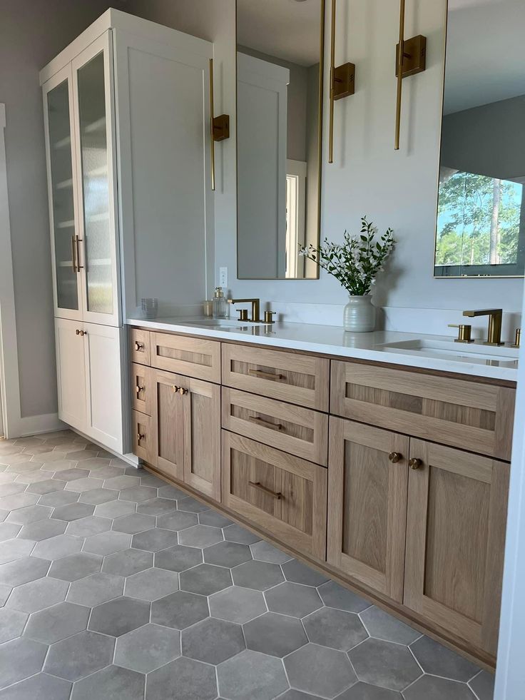 a large bathroom with two sinks and wooden cabinets