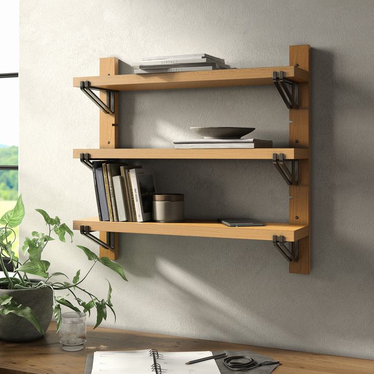 two wooden shelves on the wall above a desk with a plant and bookshelf