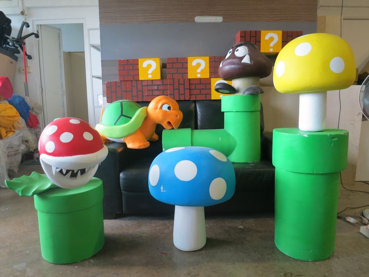 some toys are sitting on the floor in front of a chair and mushroom decorations,