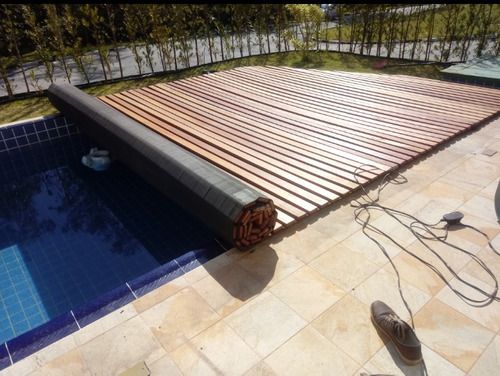 an above ground swimming pool with wooden slatted roof and tile flooring next to it