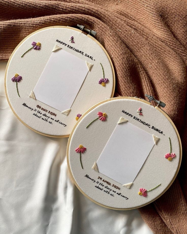 two embroidery hoop frames with flowers on them