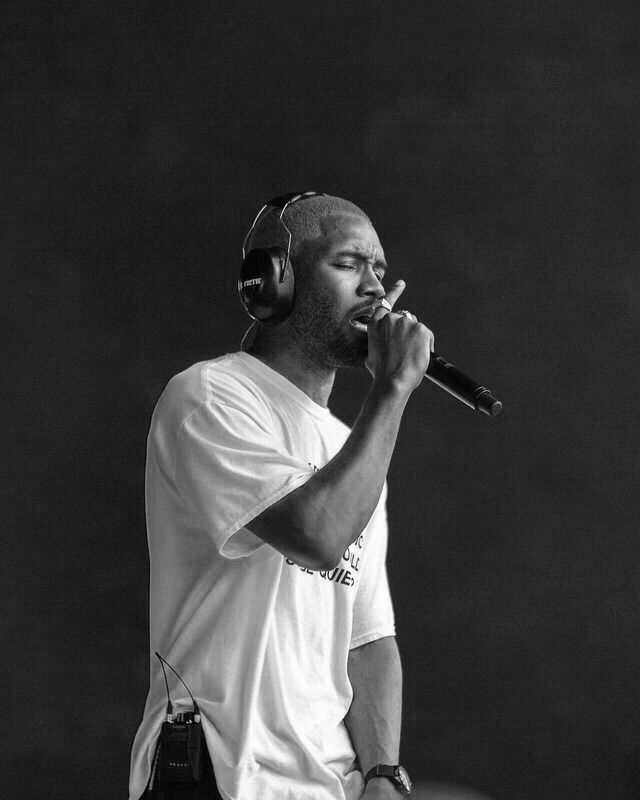 a black and white photo of a man holding a microphone in front of his face