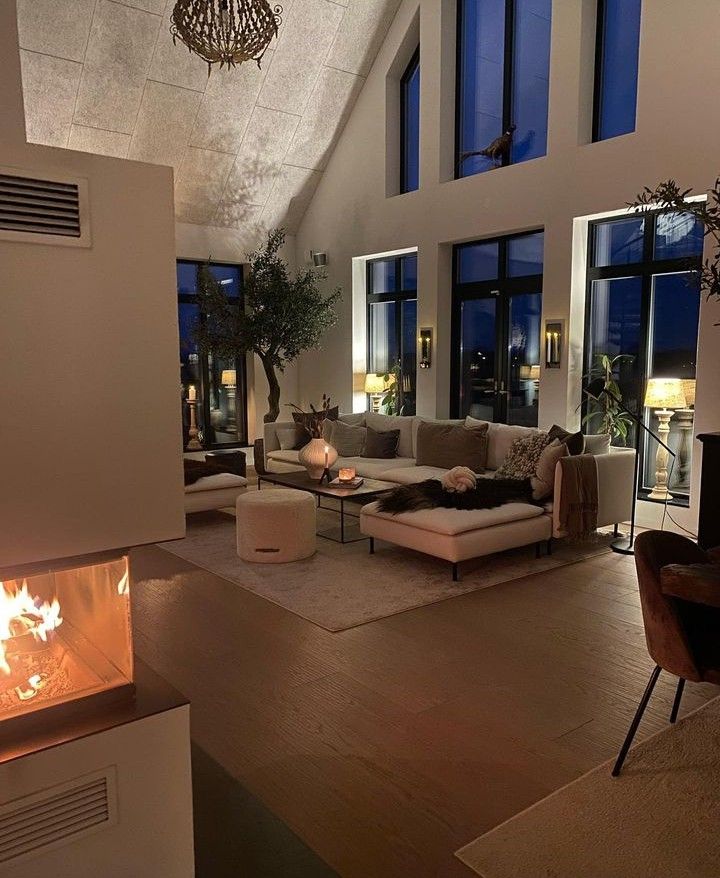 a living room filled with furniture and a fire place in the middle of it's floor