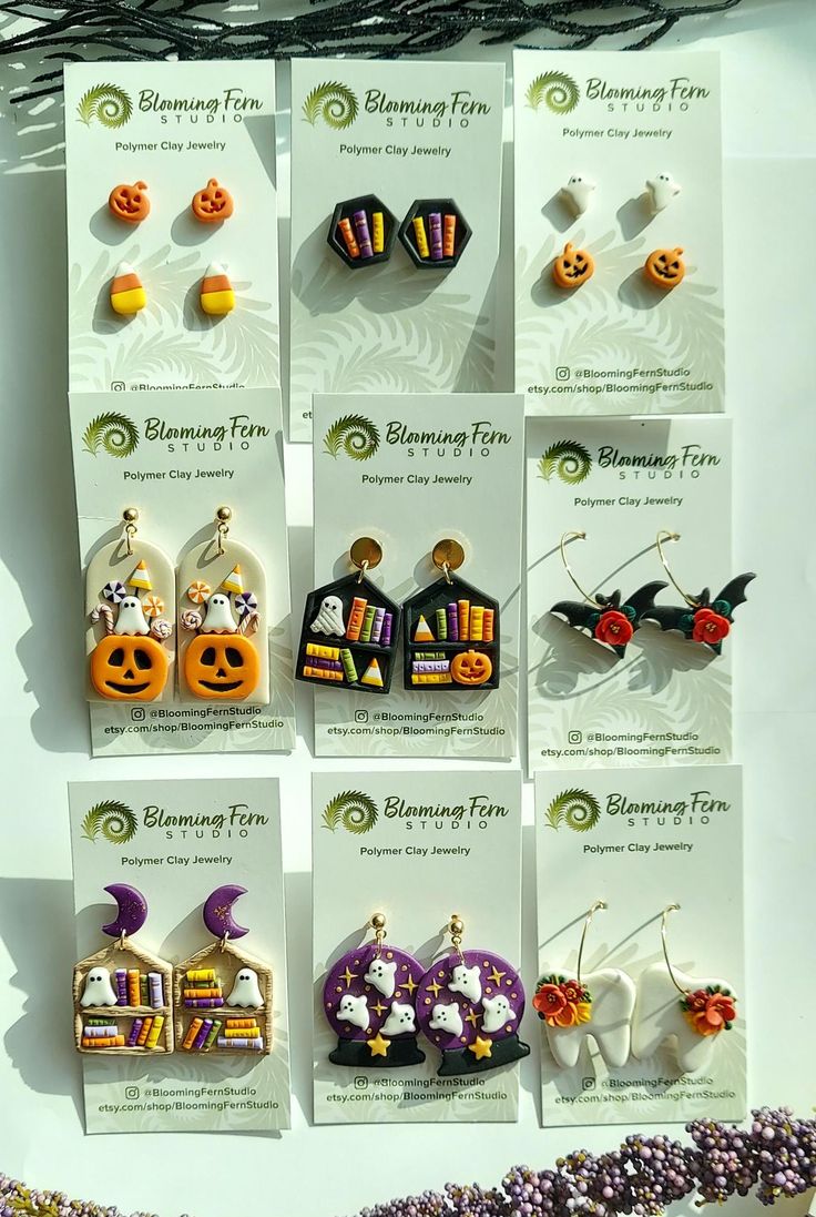 a bunch of earrings that are hanging on a wall in the shape of pumpkins and jack - o'- lanterns