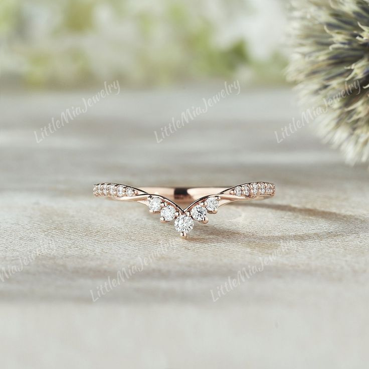 a diamond ring sitting on top of a table next to a pine tree with leaves