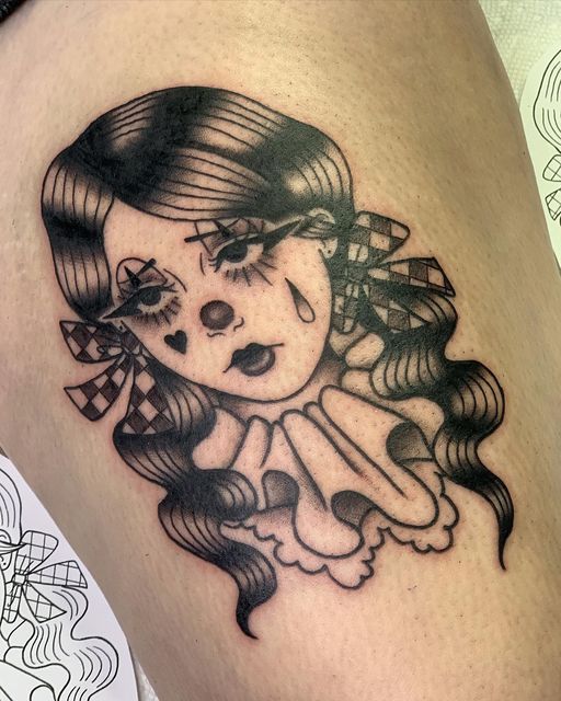 a woman's leg with a tattoo on it that has an image of a clown