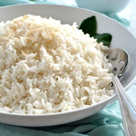 a white bowl filled with rice next to two bowls