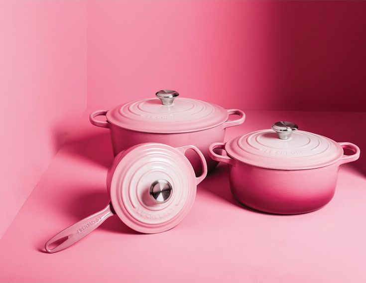 three pink pots and pans on a pink background