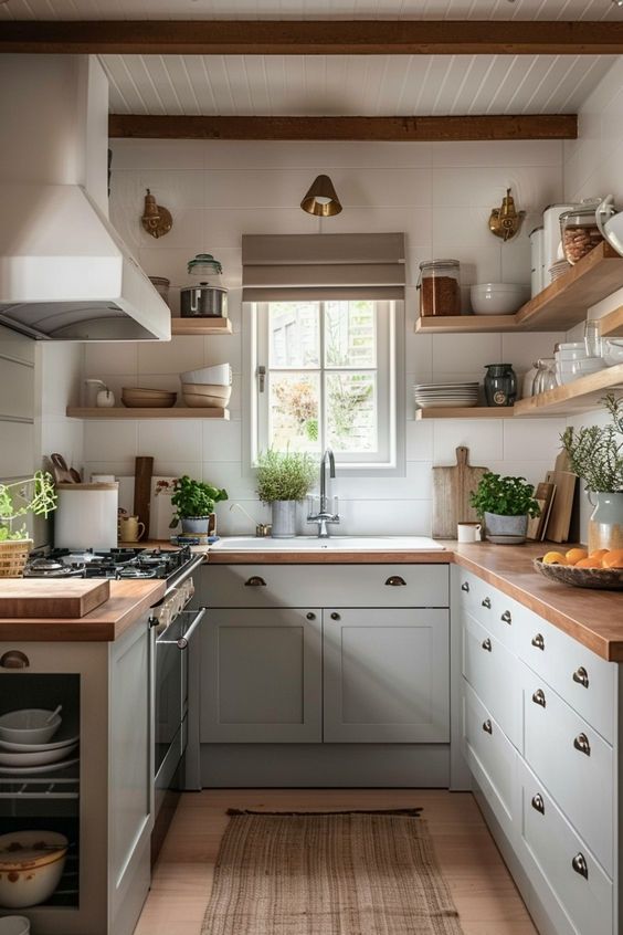 a kitchen filled with lots of counter top space and wooden shelves next to a window