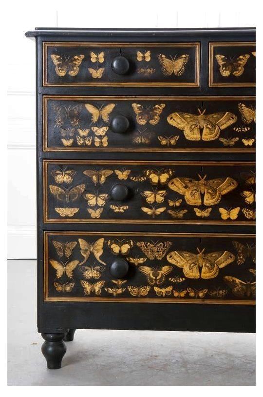 an ornate black and gold dresser with butterflies on it