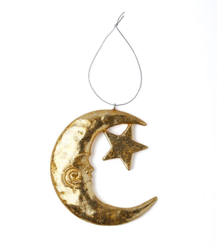 a gold crescent and star hanging from a string