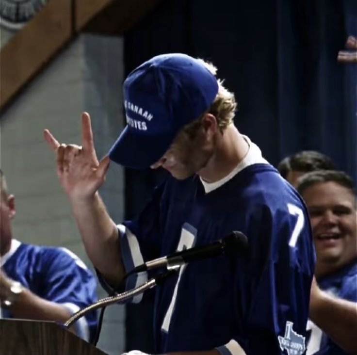 a man standing at a podium with his hands in the air