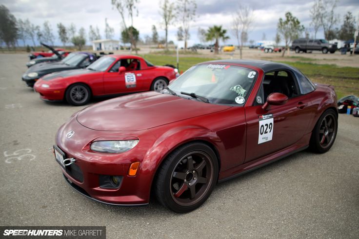 three red sports cars parked in a parking lot