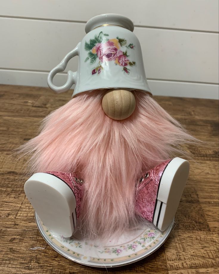 a stuffed animal with a hat on top of it's head sitting on a saucer