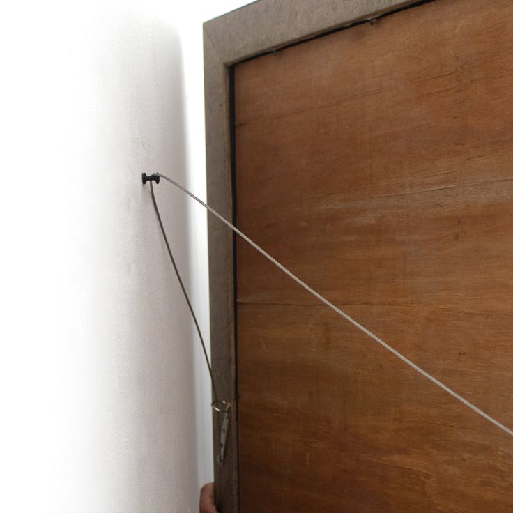 a person holding onto a door with a string attached to it