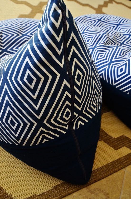 two blue and white pillows sitting on top of a rug