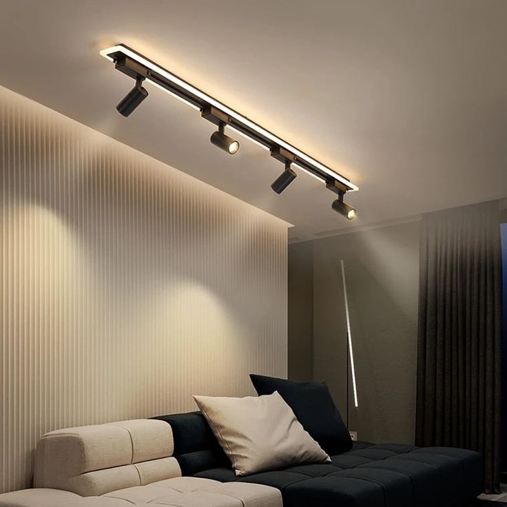 a living room with a couch and some lights on the wall above it's head