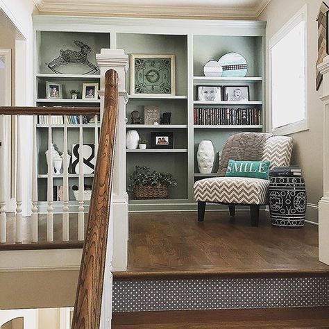 the stairs are lined with bookshelves and pictures