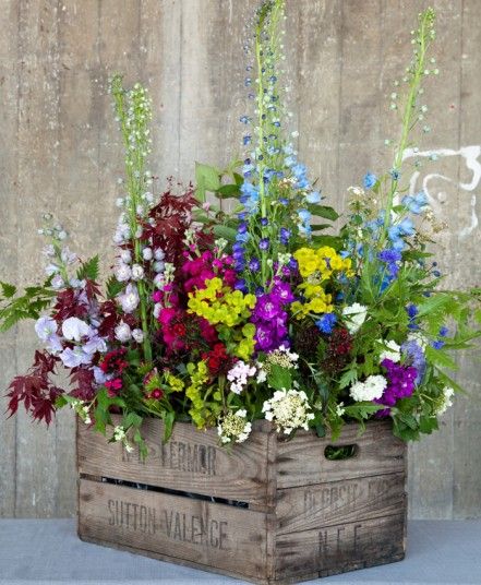 flowers in wooden crates are arranged on the table and placed next to eachother