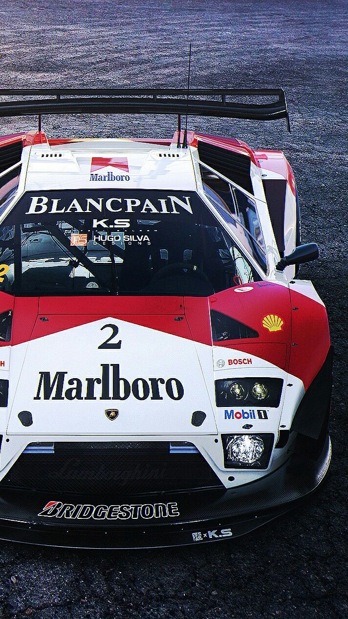 a red and white race car sitting on top of a parking lot