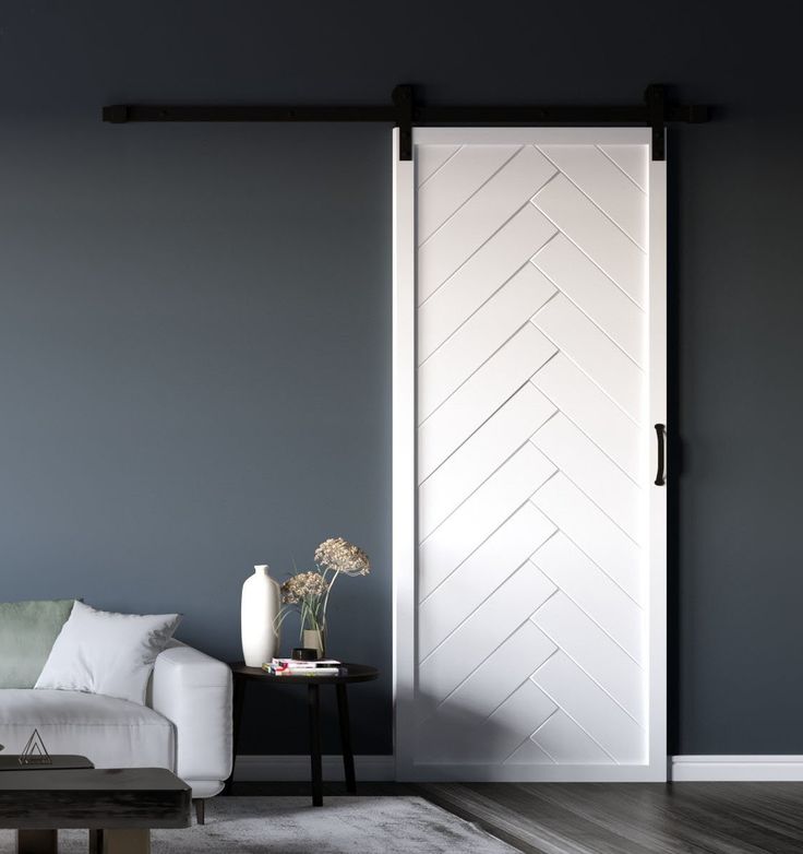 a living room with a white couch and sliding barn door in the middle of it