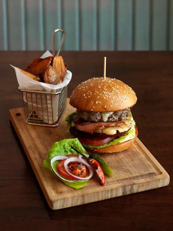 a hamburger and french fries on a cutting board