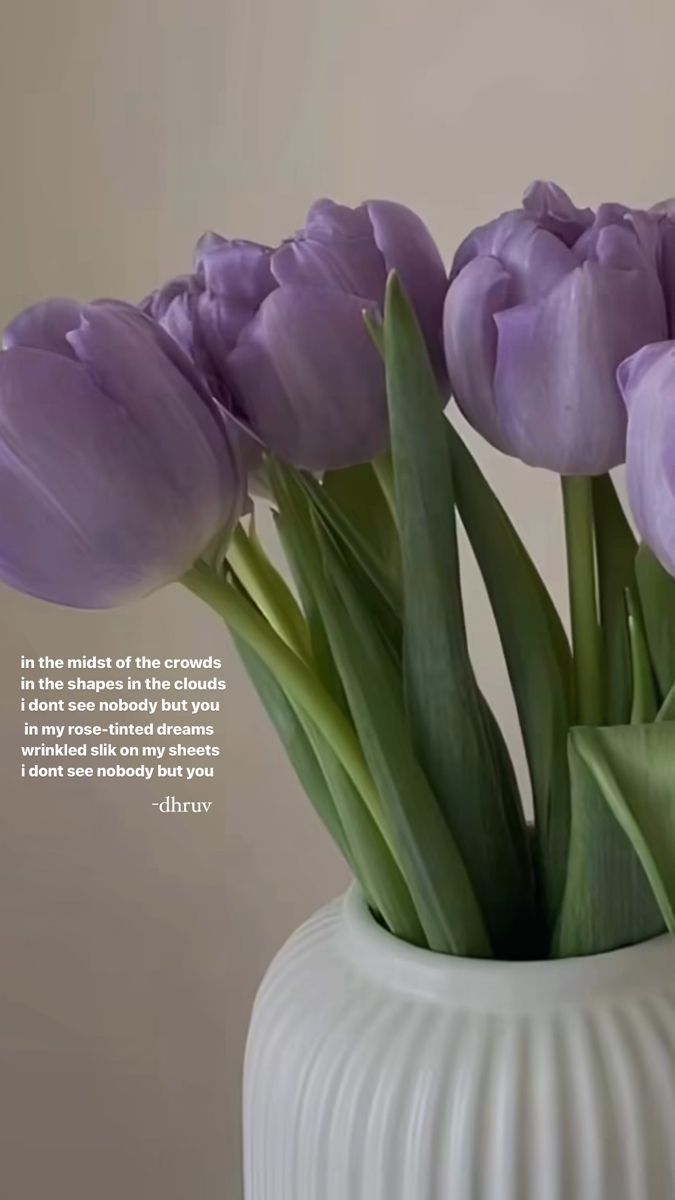 purple tulips are in a white vase with a quote on the bottom that says,