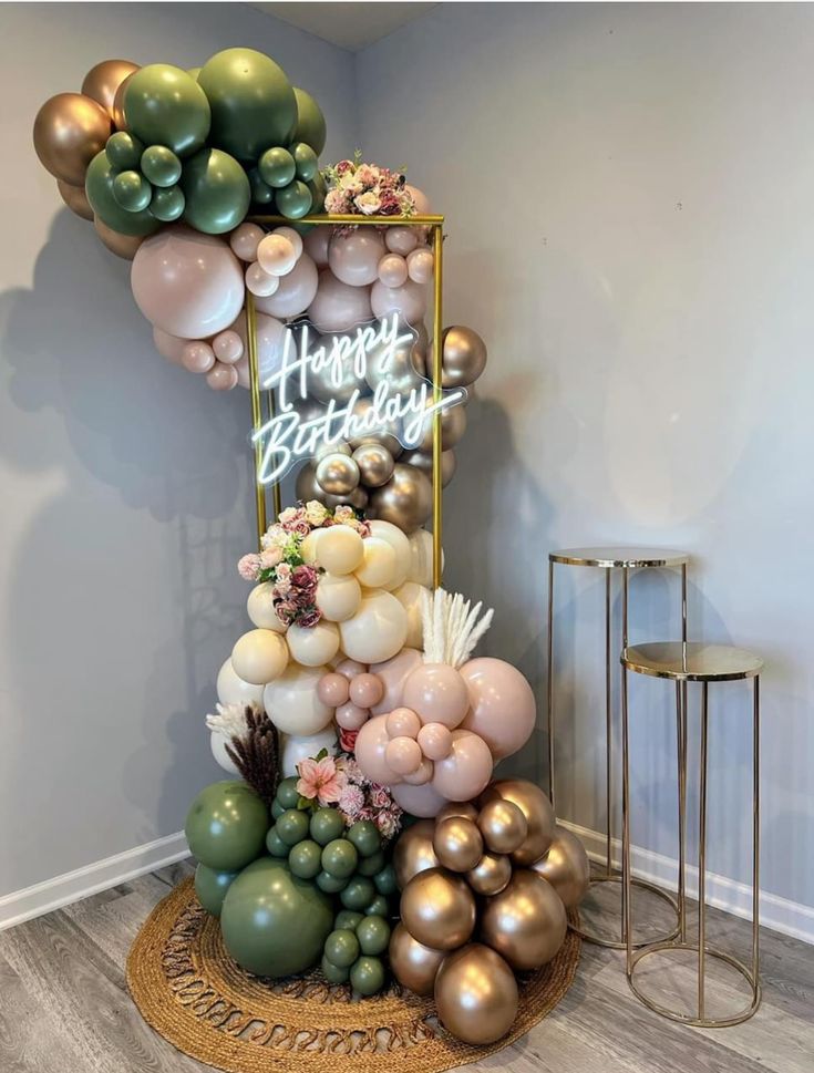 a birthday cake made out of balloons and greenery