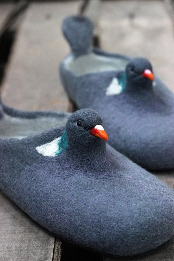 two gray slippers with green and white birds on them sitting next to each other