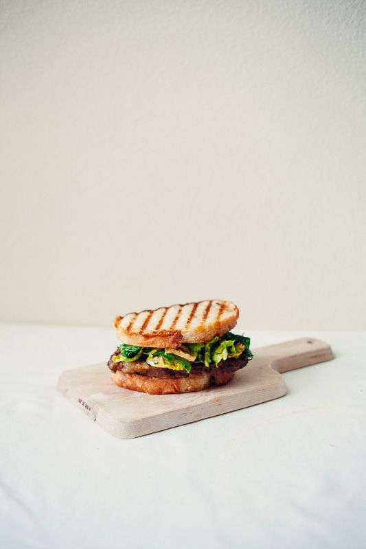 a grilled sandwich sitting on top of a cutting board next to a white wall