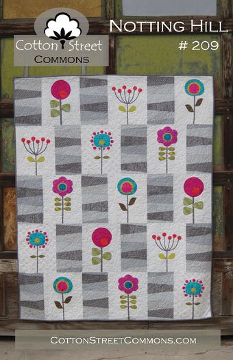 a quilted wall hanging with flowers on it