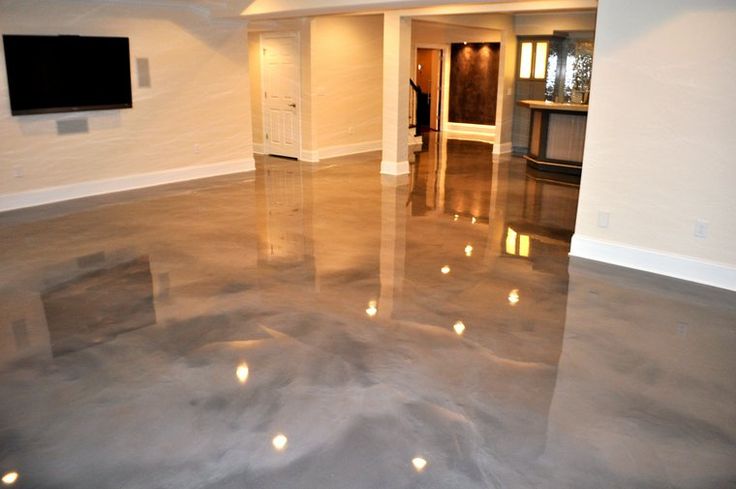 an empty living room with metallic floors and white walls