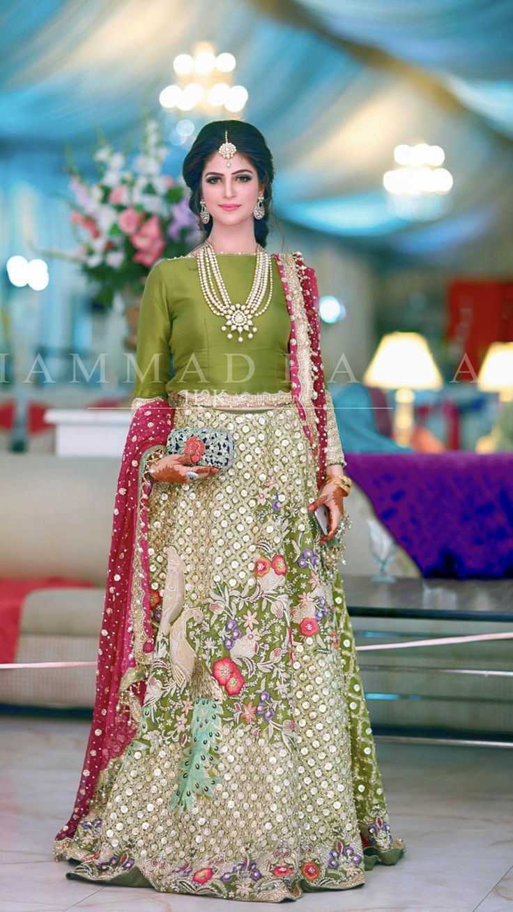 a woman in a green and gold lehenga