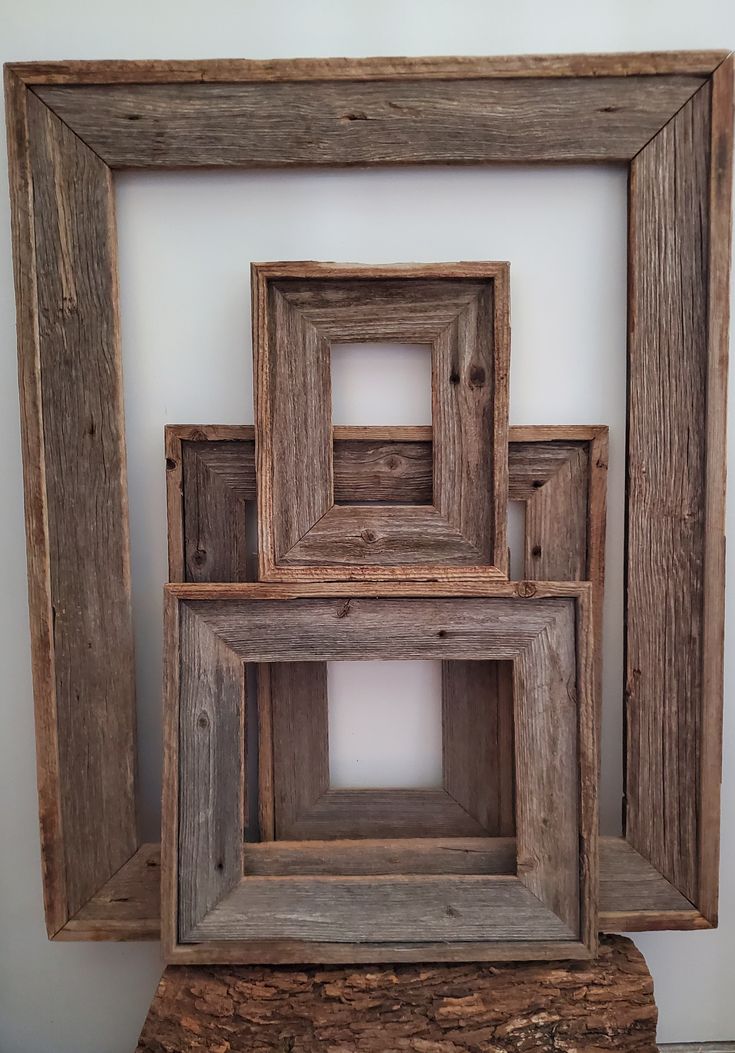 four square wooden frames stacked on top of each other in front of a white wall