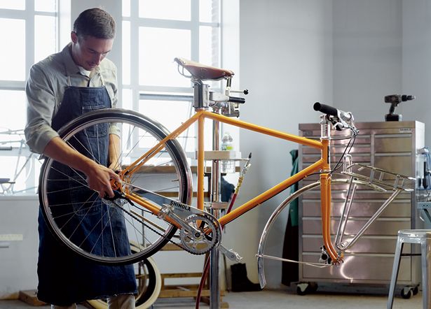 a man working on a bicycle in a garage