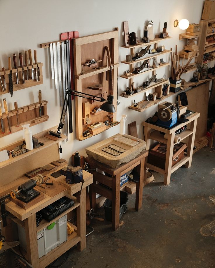 a room filled with lots of wooden workbenches and tools on shelves next to each other