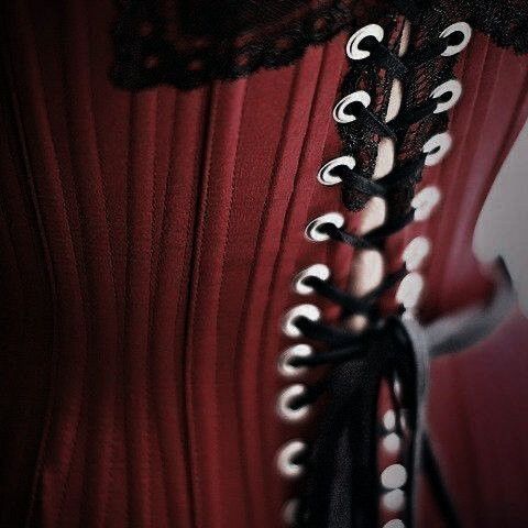 there is a corset on the back of a woman's red dress