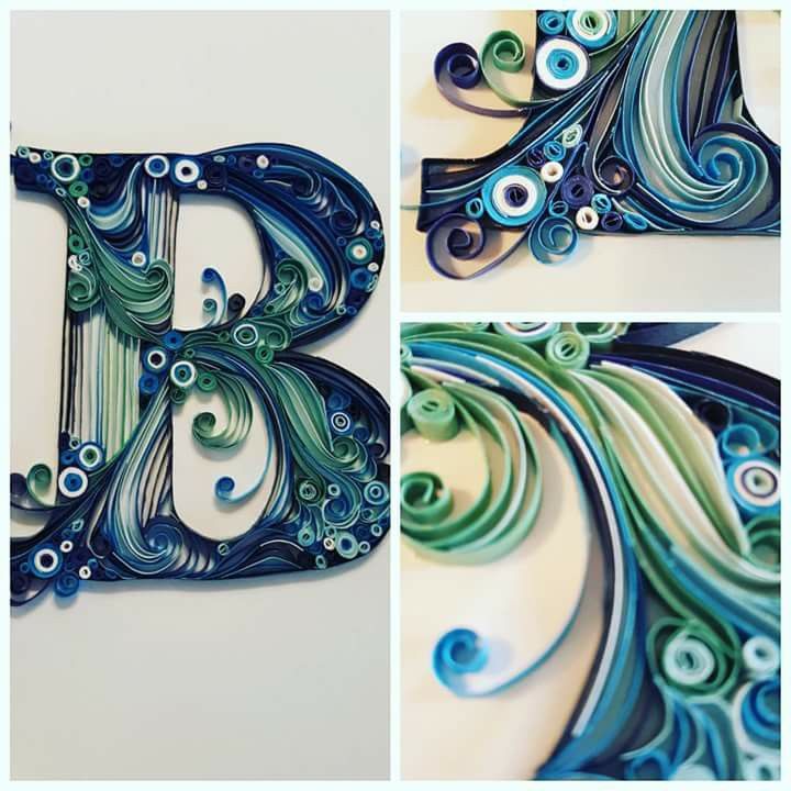 the letter b is made out of paper and has swirly blue, green and white designs on it