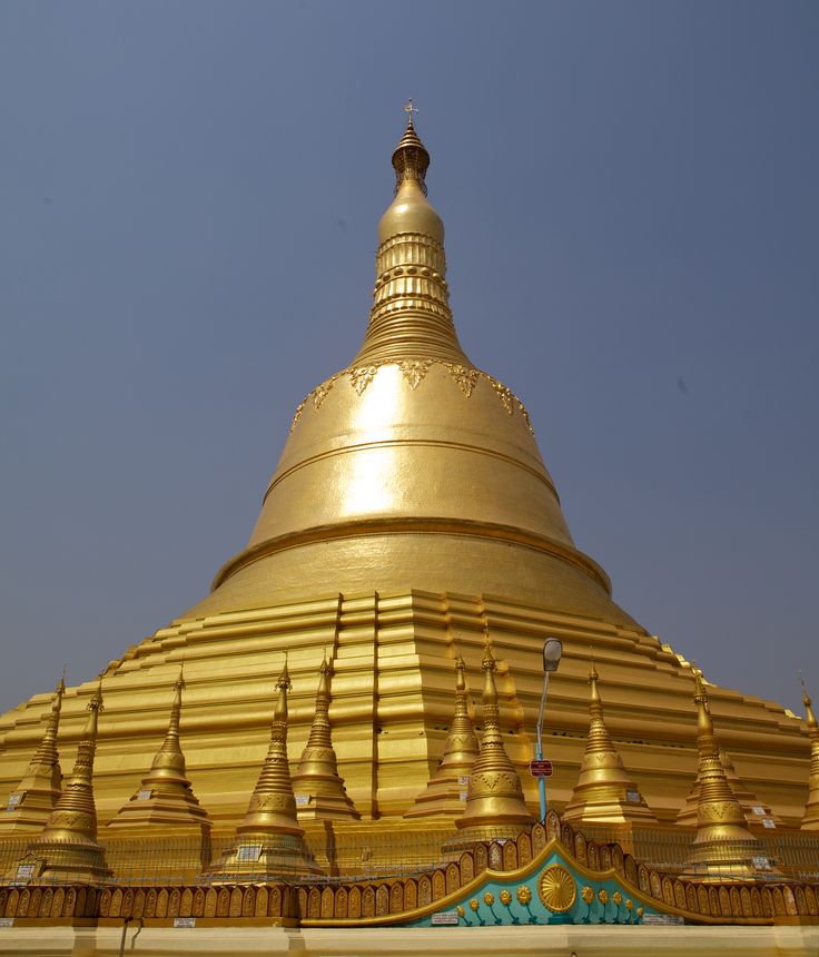 there is a large golden building with many spires on it's sides and blue sky in the background