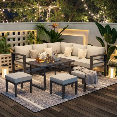 an outdoor living room is lit up with string lights