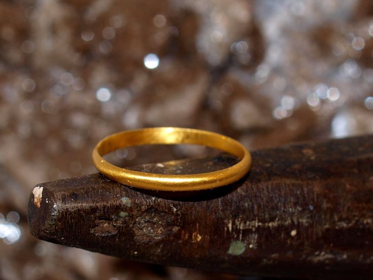 This is a solid gold ring constructed using pure 24k gold.  I start with refined .999 pure gold and melt it to red hot liquid metal, then forge it into a bar which is painstakingly rolled and hammered into the finished ring you see. The brilliance of pure 24k (99.9% gold content) gold is unmistakable. The rich color stands out from most standard jewelry that is made from 14k (58.3% gold content) and 18k (75% gold content) jewelry. The band is half-round, so it is flat on the inside and domed on Gold Specimens, Gold Nugget Ring, Natural Gold Nugget, Stacker Rings, Gold Nugget, Natural Gold, Round Rings, Solid Gold Rings, Gold Hands