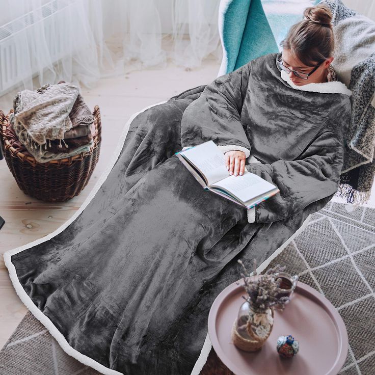 a woman sitting in a chair reading a book