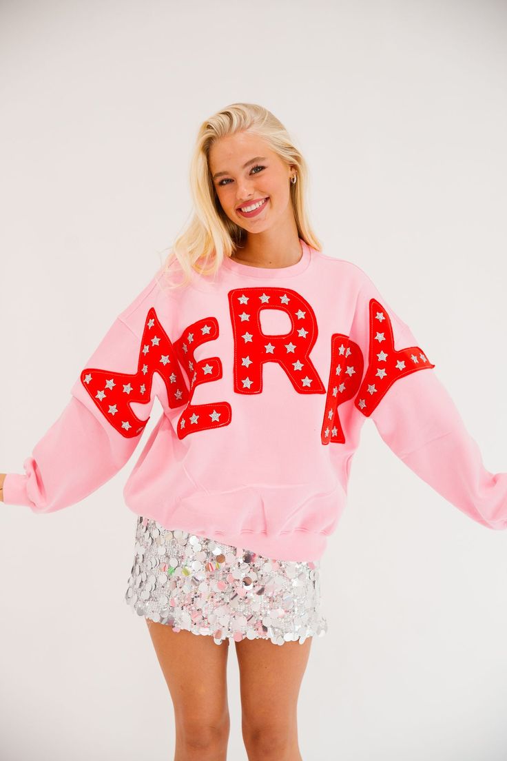 Spread holiday cheer in style with our Merry Star Pink Pullover! This playful pullover is perfect for any festive occasion, featuring bold red "Merry" cutout letters and shimmering silver star patches. Stay cozy and stand out in this quirky and fun pullover. All orders are currently shipping within 14 business days. To receive item quicker, expedited shipping is available at checkout. **All Christmas orders must be placed with expedited shipping to guarantee delivery by Dec. 24 if placed after D Casual Pink Christmas Sweater, Cute Christmas Graphic Print Sweatshirt, Merry And Bright Sweatshirt, Hot Pink Christmas Sweatshirt, Playful Pink Winter Sweater, Sequined Sweatshirt, Cheap Hoodies, Sequin Shirt, Holiday Sweatshirt