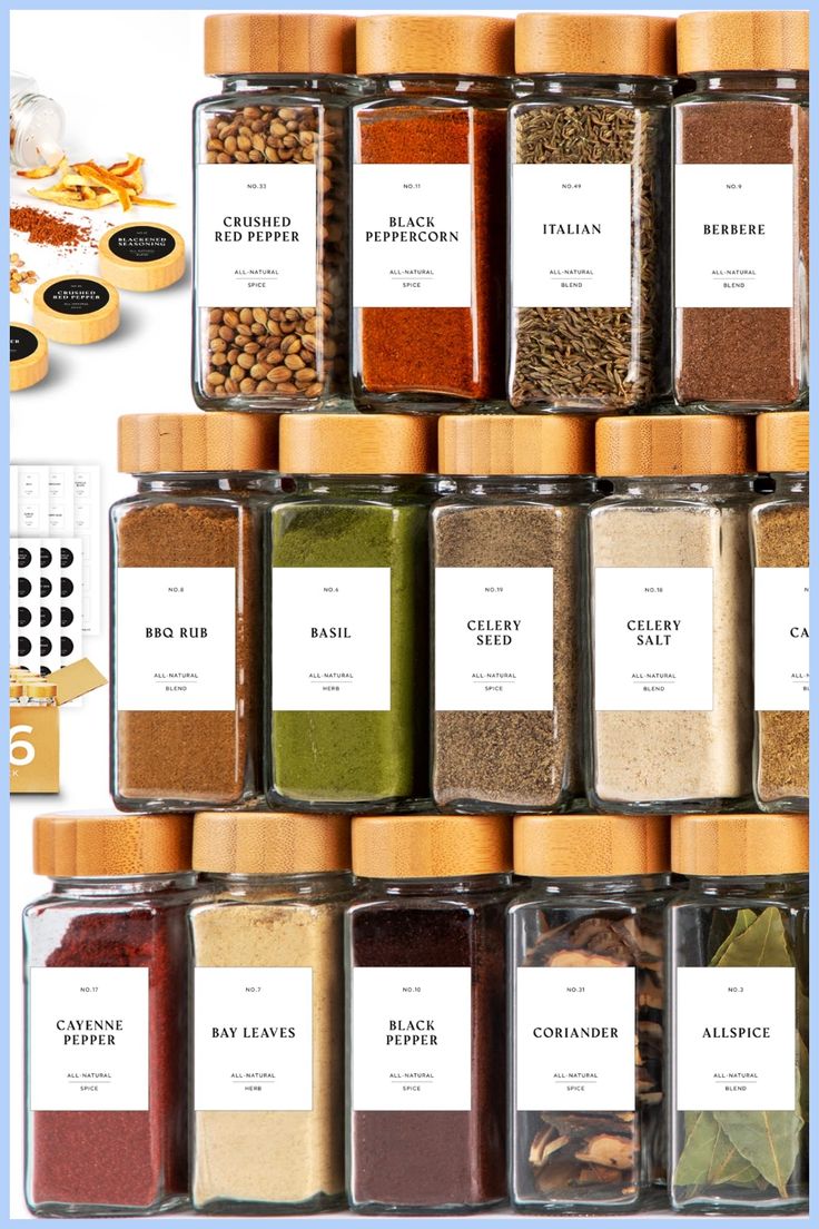 an assortment of spices and seasonings in glass jars with labels on the top, below them