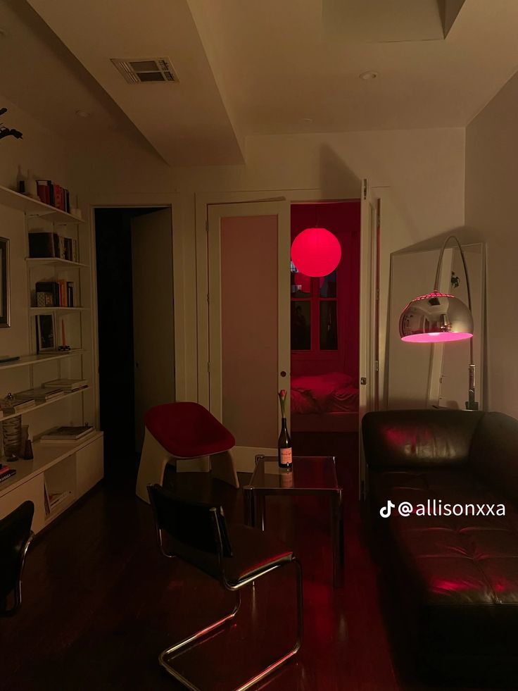 a living room filled with furniture and a red light on the wall above it's doorway