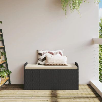 a couch sitting on top of a wooden floor next to a planter filled with potted plants