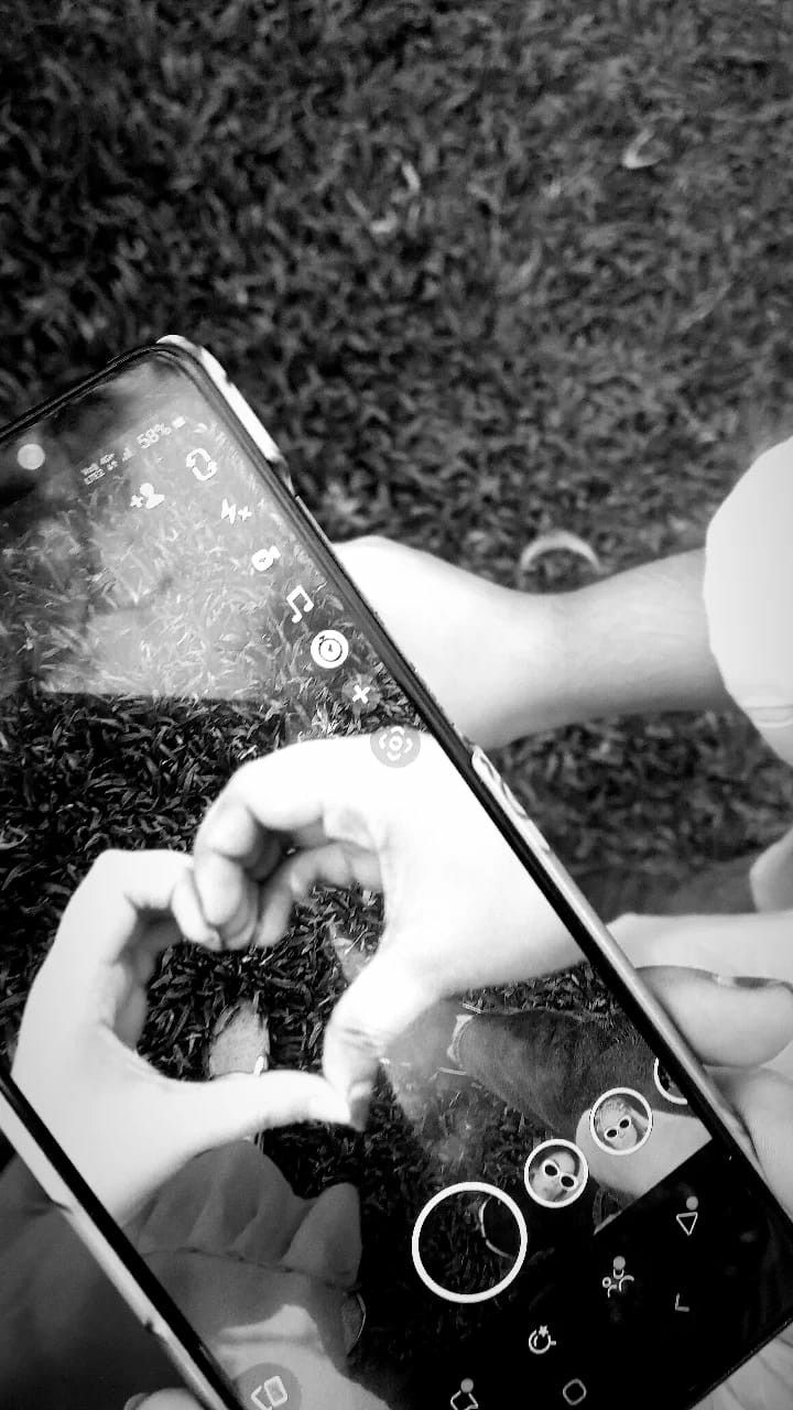 two hands touching the screen of a cell phone that has been smashed in half and is being held by another hand